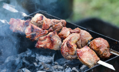 The meat on skewers is fried on the grill.