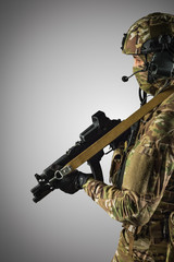 Fototapeta na wymiar Soldier holding assault rifle. Uniform conforms to special services of the Russian Federation. Shot in studio. Isolated with clipping path on grey background
