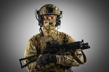 Soldier holding assault rifle. Uniform conforms to special services of the Russian Federation. Shot in studio. Isolated with clipping path on grey background