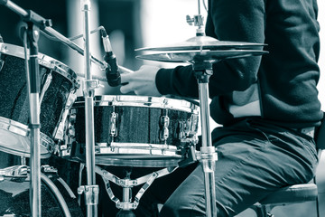 A man is sitting at the drum kit.
