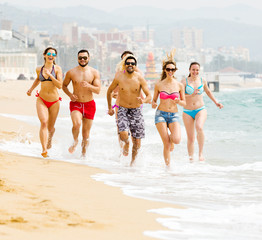 Happy people running at beach