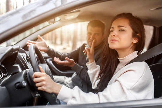 Driving instruction. A young woman learns to drive a car . Her instructor or boyfriend doesn't like the way she drives a car. But the girl is pleased with herself and does not listen to the guy.