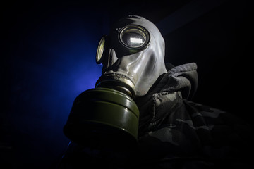 Gas mask with clouds of smoke on a dark background. Sign of radioactive contamination. Means for radiation protection. Danger of carbon monoxide poisoning.