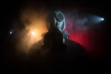 Gas mask with clouds of smoke on a dark background. Sign of radioactive contamination. Means for...