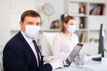 Portrait of businessman in protective medical mask at office
