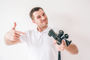 Young man isolated over white background. Guy hold black inputs cords and electrical cables in hans...