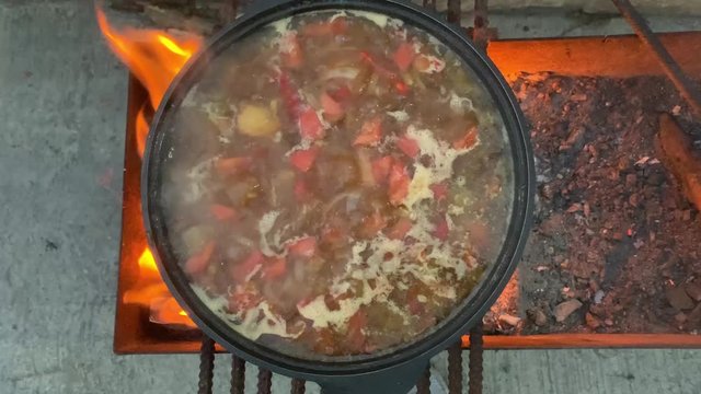 Big couldron with lagman food on open fire. Natural meat and vegetables food
