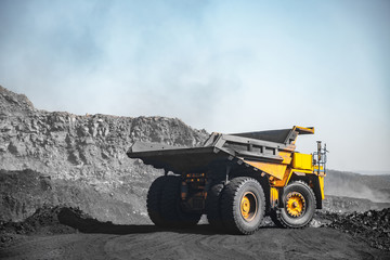Obraz premium Open pit mine industry. Yellow mining truck for coal move to excavator loads