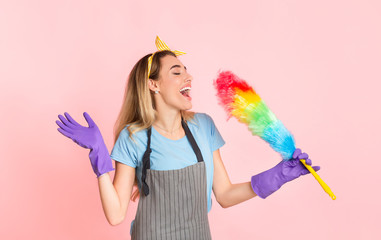 Happy housewife in apron and rubber gloves singing in multicolored brush