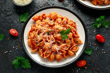 Conchiglie rigate pasta with chickpeas in tomato sauce with parmesan cheese. Healthy vegan food.