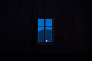 Night scene of moon seen through the window from dark room. Moonlight inside dark room