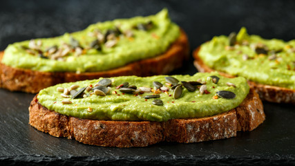 Healthy Homemade Avocado creamy Toast with nuts mix on rustic stone board