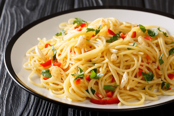 Tasty aglio e olio pasta with fried garlic, parsley and hot pepper close-up in a plate. horizontal