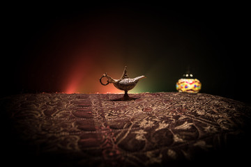 Lamp of wishes concept. Antique Aladdin arabian nights genie style oil lamp with soft light white...