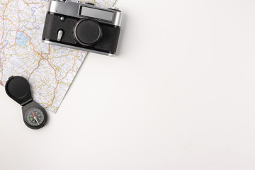 Traveler accessories. Map with old vintage camera and compas isolated on white background with empty space for text. Travel vacation concept. Summer background. Flat lay, top view. © Konstantin Maslak