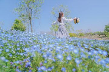 Girls and blue flowers on the hillside，sunny and happy life