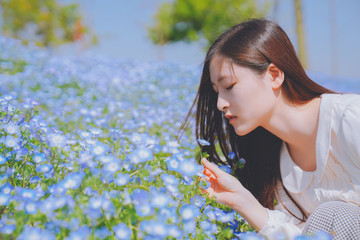 Girls and blue flowers on the hillside，sunny and happy life