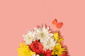 flat lay style bunch of chrysanthemum and roses flowers on pink background