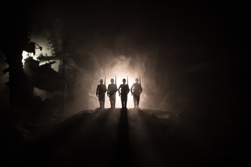 War Concept. Military silhouettes fighting scene on war fog sky background, World War Soldiers Silhouette Below Cloudy Skyline At night.