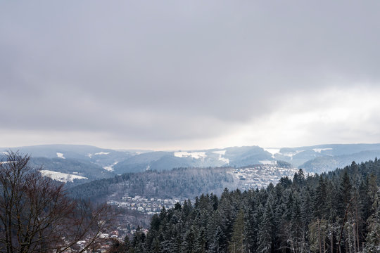 Germany, Magical white snow covered nature landscape surrounding black forest village schonach by trees in winter season with moving shadows