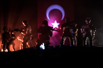 Silhouette of soldier with rifle against a turkish flag. Selective focus