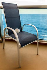 Mask n95 respirator on the chair on a cruise ship balcony on a sea background.