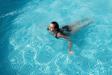 fashion photo of a sexy beautiful girl in elegant bikini posing and takes a sunbath in the swimming...