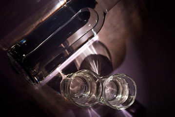Glasses with alcohol near the bottle. Transparent drink on a purple background. Top view.