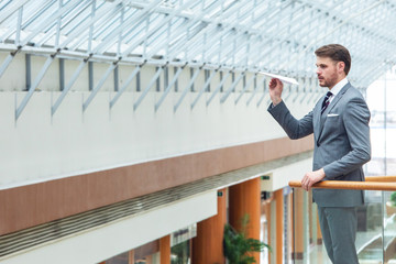 Business man throwing a paper plane