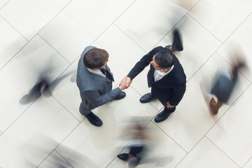 Business handshake in crowd