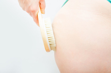 Dry massage. Massage at home, in the salon with a brush of natural bristles. Girl does massage legs, buttocks in  close-up