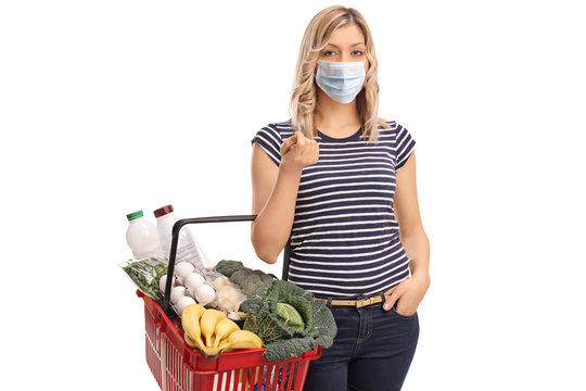 Young Woman Wearing A Protective Face Mask And Carrying A Shopping Basket