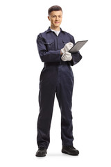 Full length portrait of a mechanic in a uniform writing on a clipboard