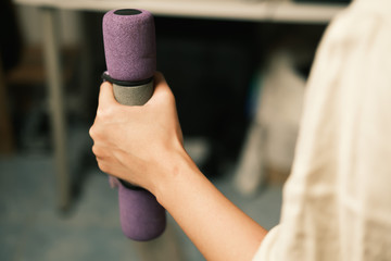 Unrecognized woman workout at home with Dumbbells medium closeup shot