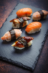 Assorted sushi on a stone plate, side view