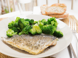 dish of fried dorado fish fillet with boiled broccoli