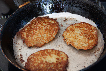 Potato pancakes are fried in a hot pan. Pancakes.Top view 
