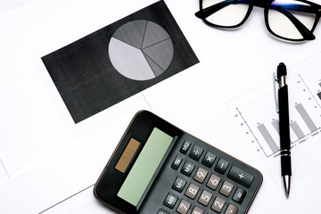 Top view Close up of business working data document graph chart report marketing research calculator pen glasses documents on the table, office workplace.Business office concept.