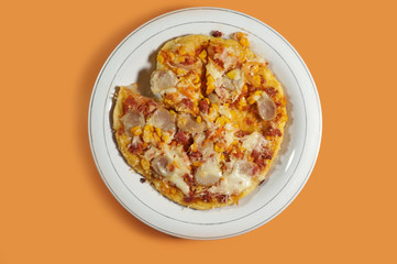 Delicious homemade pizza with sweet corn, beef sausage, Shredded beef, cheese and sausages on yellow background, close up         