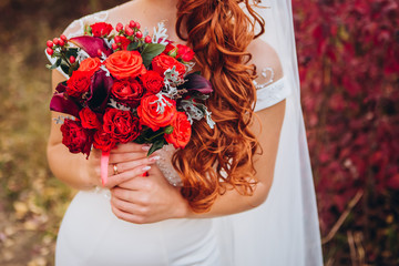 bride in a white dress with a chic bouquet in her hands. Luxury wedding bouquet. The girl is holding flowers - roses, peonies, archedes.