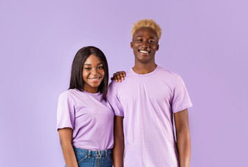 Romantic African American couple smiling on color background