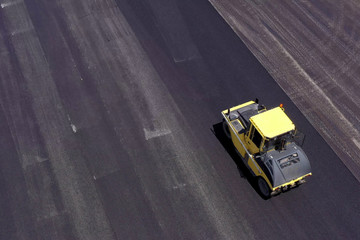 Asphalt roller pressing a new road at the local port.
