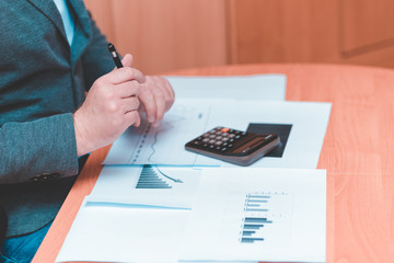 Side view of Cropped picture businessman working on desk office  financial graph with using a...