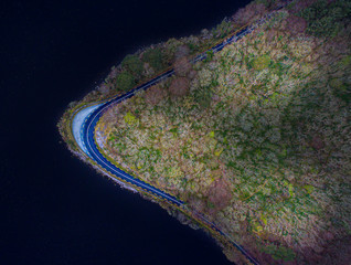Drone aerial view of scenic road forest and lake from above