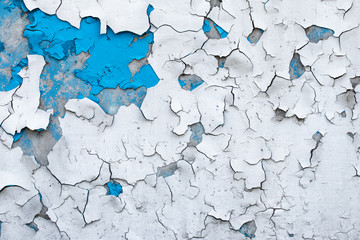 Peeling paint on a concrete wall. Blue and white painted abstract background, grunge cracked...