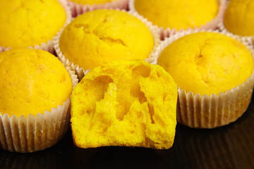 Cupcakes on black plate, closeup. Half of yellow pumpkin muffin. Homemade bakery