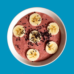 Banana and strawberry smoothie garnished with bananas and black sesame seeds
