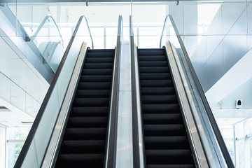 two escalators in the mall and business area, bright background