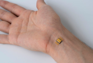 microchip is connected to a man hand. implantation of a chip under the human skin.