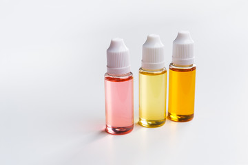 three e cigarettes liquid bottles on white background
